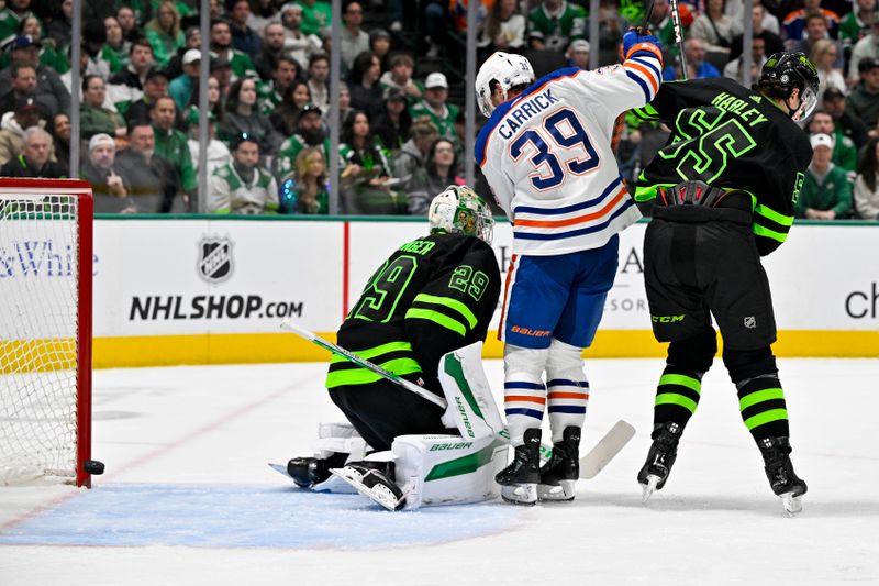 Apr 3, 2024; Dallas, Texas, USA; A view of the puck as it hits the post past Dallas Stars goaltender Jake Oettinger (29) and defenseman Thomas Harley (55) and Edmonton Oilers center Sam Carrick (39) during the first period at the American Airlines Center. Mandatory Credit: Jerome Miron-USA TODAY Sports