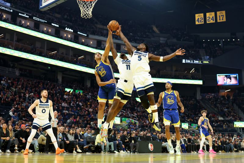 SAN FRANCISCO, CALIFORNIA - DECEMBER 06: Trayce Jackson-Davis #32 of the Golden State Warriors goes for a rebound against Naz Reid #11 and Anthony Edwards #5 of the Minnesota Timberwolves in the first half at Chase Center on December 06, 2024 in San Francisco, California. NOTE TO USER: User expressly acknowledges and agrees that, by downloading and/or using this photograph, user is consenting to the terms and conditions of the Getty Images License Agreement.   (Photo by Ezra Shaw/Getty Images)