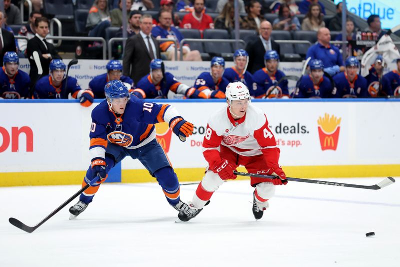 Oct 22, 2024; Elmont, New York, USA; Detroit Red Wings right wing Jonatan Berggren (48) controls the puck against New York Islanders right wing Simon Holmstrom (10) during the first period at UBS Arena. Mandatory Credit: Brad Penner-Imagn Images