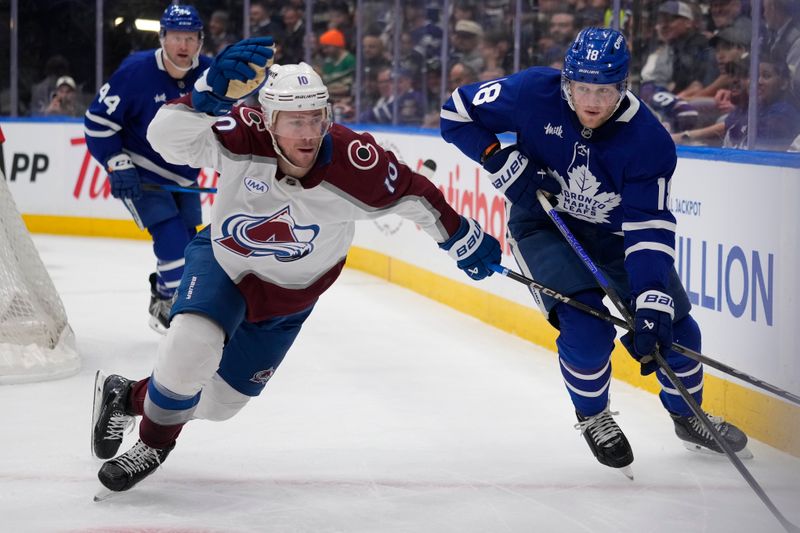 Mar 19, 2025; Toronto, Ontario, CAN; Colorado Avalanche forward Charlie Coyle (10) goes to check Toronto Maple Leafs forward Steven Lorentz (18) along the boards during the second period at Scotiabank Arena. Mandatory Credit: John E. Sokolowski-Imagn Images