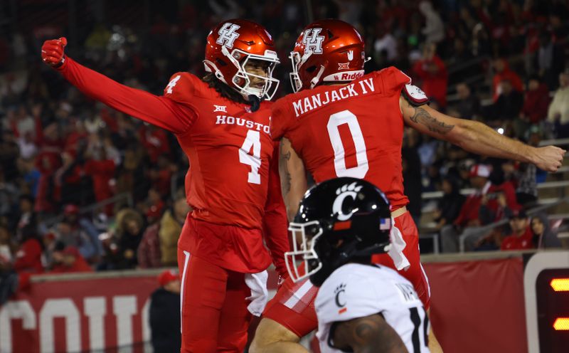 Nov 11, 2023; Houston, Texas, USA; Houston Cougars wide receiver Samuel Brown (4) celebrates wide receiver Joseph Manjack IV (0) touchdown reception against Cincinnati Bearcats defensive back Taj Ward (15) in the first half at TDECU Stadium. Mandatory Credit: Thomas Shea-USA TODAY Sports