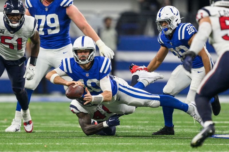 Houston Texans linebacker Christian Harris (48) pulled down Indianapolis Colts quarterback Gardner Minshew (10) during an NFL football game, Saturday, Jan. 6, 2024, in Indianapolis. (AP Photo/Zach Bolinger)