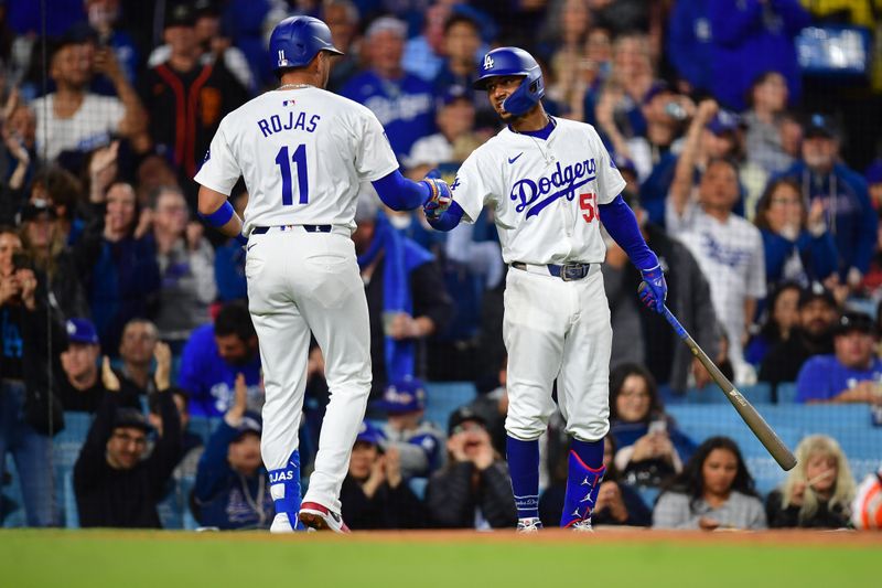 Apr 3, 2024; Los Angeles, California, USA; Los Angeles Dodgers shortstop Miguel Rojas (11) is greeted by second baseman Mookie Betts (50) after hitting a solo home run against the San Francisco Giants during the fourth inning at Dodger Stadium. Mandatory Credit: Gary A. Vasquez-USA TODAY Sports