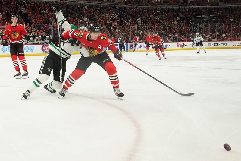 Nov 27, 2024; Chicago, Illinois, USA; Chicago Blackhawks defenseman Connor Murphy (5) goes for the puck against the Dallas Stars during the second period at United Center. Mandatory Credit: David Banks-Imagn Images