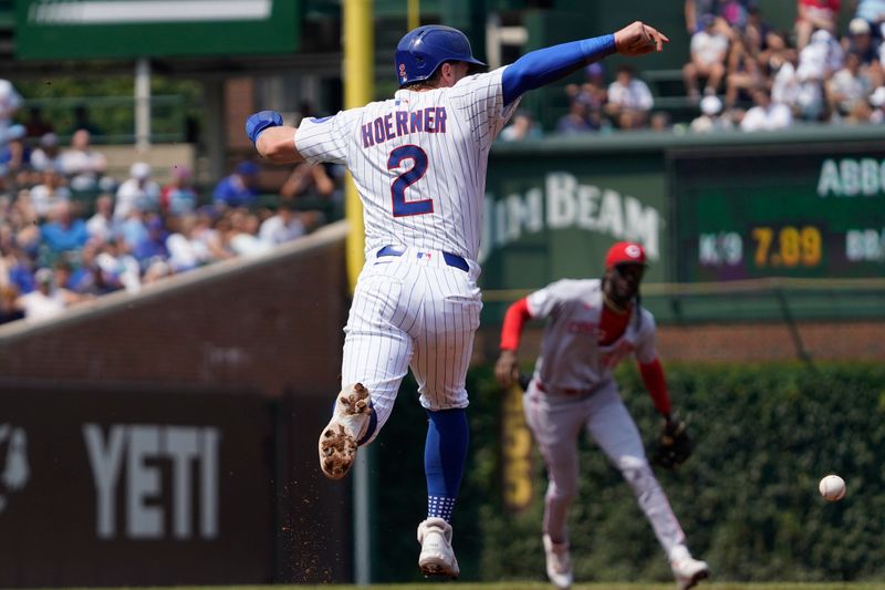 Aug 6, 2025; Chicago, Illinois, USA;  Chicago Cubs second base Nico Hoerner (2) jumps out of the way of a single hit by first base Justin Turner (not pictured) against the Cincinnati Reds during the third inning at Wrigley Field. Mandatory Credit: David Banks-Imagn Images