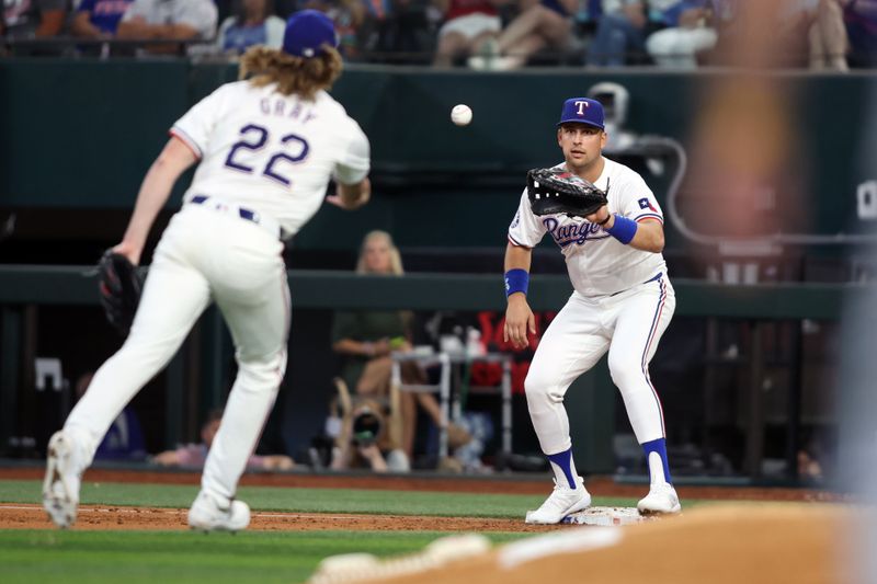 Jun 22, 2024; Arlington, Texas, USA; Texas Rangers pitcher Jon Gray (22) tosses the ball to first base Nathaniel Lowe (30) for the out in the game against the Kansas City Royals at Globe Life Field. Mandatory Credit: Tim Heitman-USA TODAY Sports