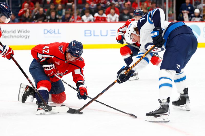 Mar 24, 2024; Washington, District of Columbia, USA; Washington Capitals defenseman Martin Fehervary (42) and Winnipeg Jets right wing Tyler Toffoli (73) battle for the puck during the second period at Capital One Arena. Mandatory Credit: Amber Searls-USA TODAY Sports