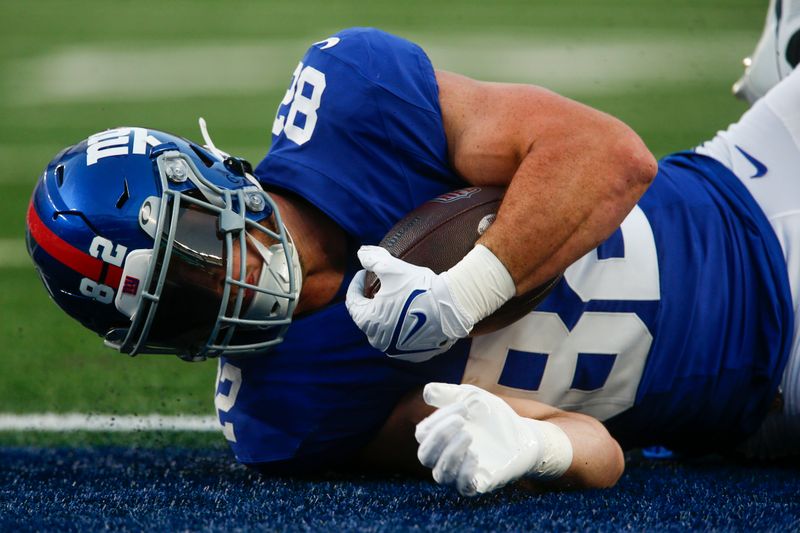 New York Giants' Daniel Bellinger scores a touchdown during the first half of an NFL preseason football game against the Carolina Panthers, Friday, Aug. 18, 2023, in East Rutherford, N.J. (AP Photo/John Munson)