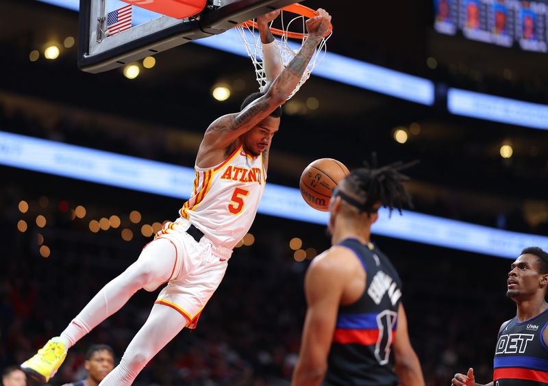 ATLANTA, GEORGIA - APRIL 03:  Dejounte Murray #5 of the Atlanta Hawks dunks an alley-oop against Tosan Evbuomwan #18 and Jalen Duren #0 of the Detroit Pistons during the second quarter at State Farm Arena on April 03, 2024 in Atlanta, Georgia.  NOTE TO USER: User expressly acknowledges and agrees that, by downloading and/or using this photograph, user is consenting to the terms and conditions of the Getty Images License Agreement.  (Photo by Kevin C. Cox/Getty Images)