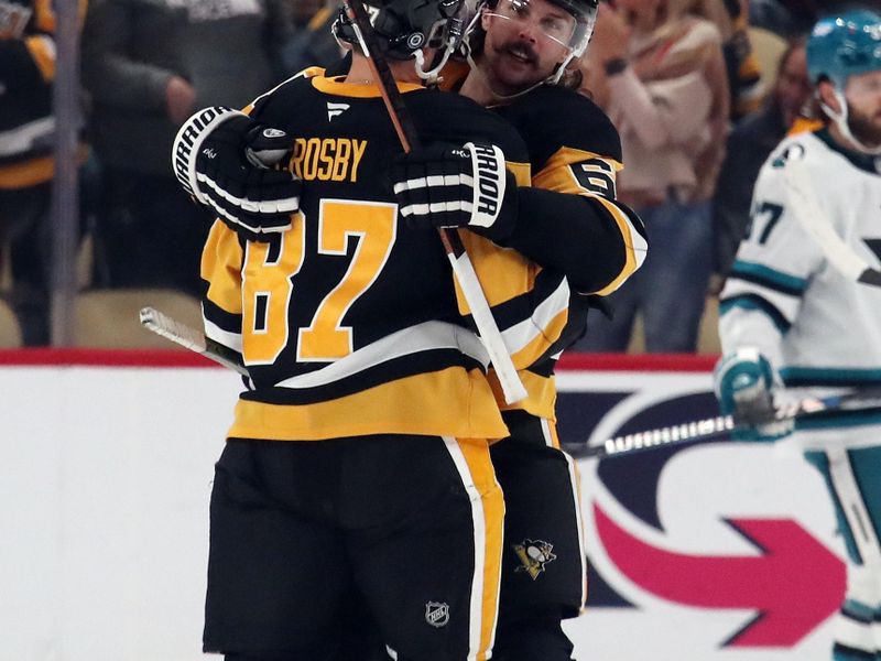 Nov 16, 2024; Pittsburgh, Pennsylvania, USA;  Pittsburgh Penguins defenseman Erik Karlsson (65) congratulates center Sidney Crosby (87) on his goal against the San Jose Sharks during the second period at PPG Paints Arena. Mandatory Credit: Charles LeClaire-Imagn Images