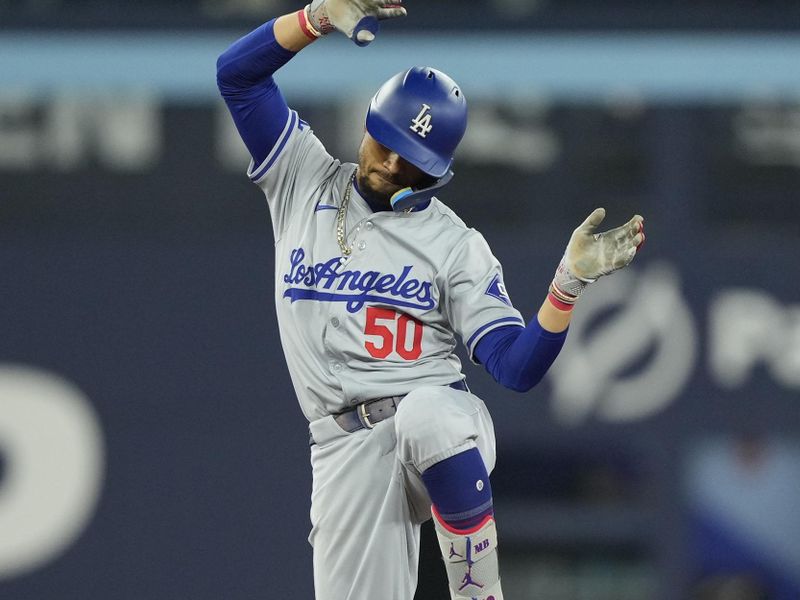 Apr 28, 2024; Toronto, Ontario, CAN; Los Angeles Dodgers shortstop Mookie Betts (50) celebrates his double against the Toronto Blue Jays during the eighth inning at Rogers Centre. Mandatory Credit: John E. Sokolowski-USA TODAY Sports