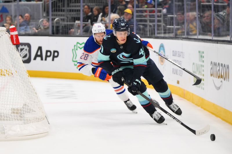 Oct 2, 2024; Seattle, Washington, USA; Seattle Kraken defenseman Ryker Evans (41) advances the puck while defended by Edmonton Oilers right wing Connor Brown (28) during the second period at Climate Pledge Arena. Mandatory Credit: Steven Bisig-Imagn Images