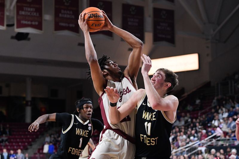 Jan 14, 2023; Chestnut Hill, Massachusetts, USA; Boston College Eagles forward Devin McGlockton (21) shoots through the defense of Wake Forest Demon Deacons forward Andrew Carr (11) during the second half at Conte Forum. Mandatory Credit: Eric Canha-USA TODAY Sports