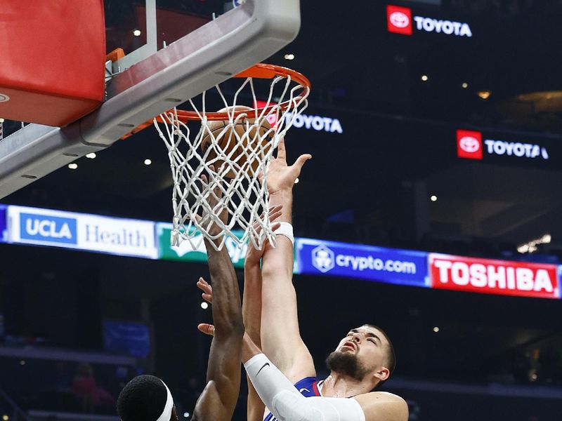 LOS ANGELES, CALIFORNIA - NOVEMBER 27:  Ivica Zubac #40 of the LA Clippers takes a shot against Justin Holiday #9 of the Denver Nuggets in the first half at Crypto.com Arena on November 27, 2023 in Los Angeles, California.  NOTE TO USER: User expressly acknowledges and agrees that, by downloading and/or using this photograph, user is consenting to the terms and conditions of the Getty Images License Agreement. (Photo by Ronald Martinez/Getty Images)