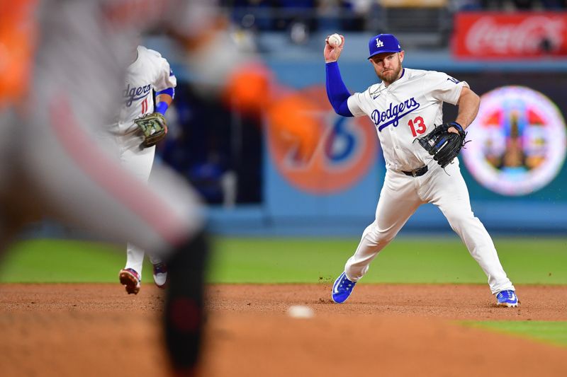 Apr 3, 2024; Los Angeles, California, USA; Los Angeles Dodgers third baseman Max Muncy (13) throws to first for the out against San Francisco Giants second baseman Thairo Estrada (39) during the sixth inning at Dodger Stadium. Mandatory Credit: Gary A. Vasquez-USA TODAY Sports