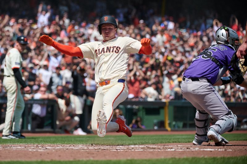 May 4, 2025; San Francisco, California, USA; San Francisco Giants catcher Patrick Bailey (14) slides into home plate to score a run against Colorado Rockies catcher Jacob Stallings (25) during the fifth inning at Oracle Park. Mandatory Credit: Robert Edwards-Imagn Images