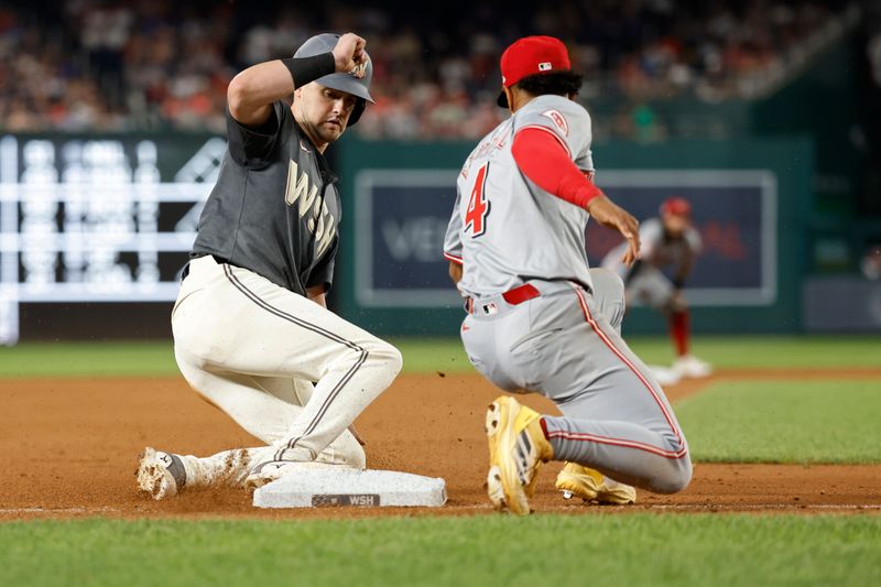 Jul 20, 2024; Washington, District of Columbia, USA; Washington Nationals outfielder Lane Thomas (28) steals third base ahead of a tag by Cincinnati Reds third baseman Santiago Espinal (4) during the seventh inning at Nationals Park. Mandatory Credit: Geoff Burke-USA TODAY Sports