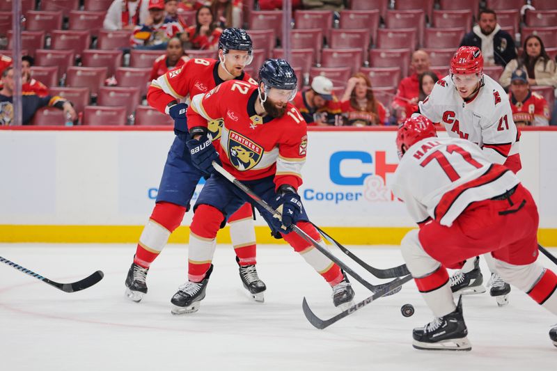 May 26, 2025; Sunrise, Florida, USA; Carolina Hurricanes left wing Taylor Hall (71) moves the puck as Florida Panthers left wing Jonah Gadjovich (12) defends during the third period in game four of the Eastern Conference Final of the 2025 Stanley Cup Playoffs at Amerant Bank Arena. Mandatory Credit: Sam Navarro-Imagn Images