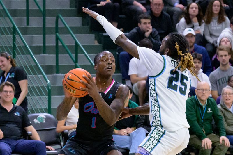 Jan 11, 2024; New Orleans, Louisiana, USA; Tulane Green Wave guard Jaylen Forbes (25) guards against Florida Atlantic Owls guard Johnell Davis (1) during the first half at Avron B. Fogelman Arena in Devlin Fieldhouse. Mandatory Credit: Matthew Hinton-USA TODAY Sports