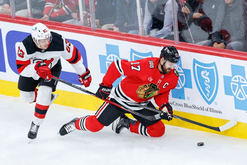 Nov 12, 2025; Chicago, Illinois, USA; Chicago Blackhawks left wing Nick Foligno (17) keeps the puck away from New Jersey Devils left wing Jesper Bratt (63) during the first period at United Center. Mandatory Credit: Kamil Krzaczynski-Imagn Images Nov 12, 2025; Chicago, Illinois, USA; Chicago Blackhawks left wing Nick Foligno (17) keeps the puck away from New Jersey Devils left wing Jesper Bratt (63) during the first period at United Center. Mandatory Credit: Kamil Krzaczynski-Imagn Images