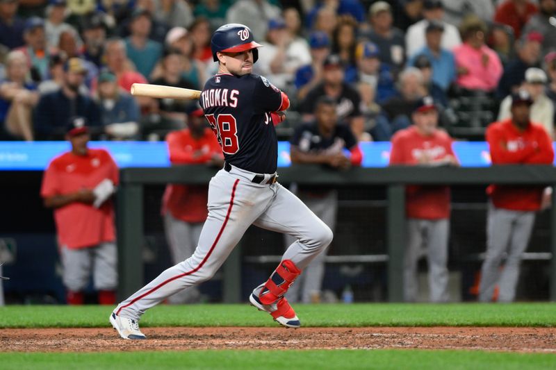 Jun 27, 2023; Seattle, Washington, USA; Washington Nationals right fielder Lane Thomas (28) hits a two run RBI double against the Seattle Mariners during the eleventh inning at T-Mobile Park. Mandatory Credit: Steven Bisig-USA TODAY Sports