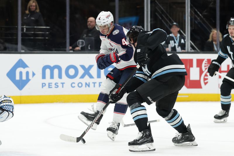 Jan 31, 2025; Salt Lake City, Utah, USA;  Columbus Blue Jackets center Cole Sillinger (4) tries to kick the puck into the net against the Utah Hockey Club during the third period at Delta Center. Mandatory Credit: Chris Nicoll-Imagn Images