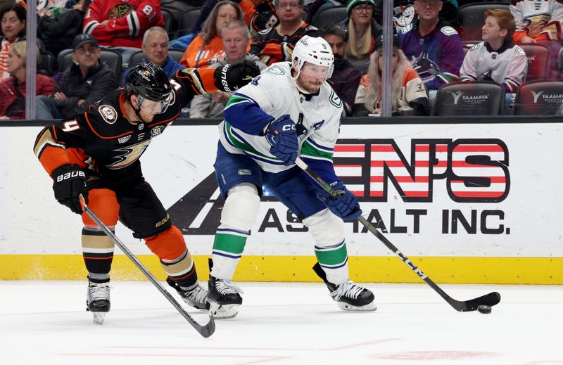 Mar 3, 2024; Anaheim, California, USA; Vancouver Canucks center J.T. Miller (9) controls the puck against Anaheim Ducks defenseman Cam Fowler (4) during the third period at Honda Center. Mandatory Credit: Jason Parkhurst-USA TODAY Sports