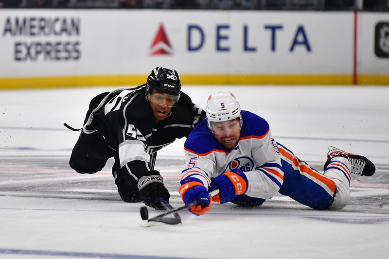 Apr 29, 2023; Los Angeles, California, USA; Edmonton Oilers defenseman Cody Ceci (5) plays for the puck against Los Angeles Kings center Quinton Byfield (55) during the second period in game six of the first round of the 2023 Stanley Cup Playoffs at Crypto.com Arena. Mandatory Credit: Gary A. Vasquez-USA TODAY Sports