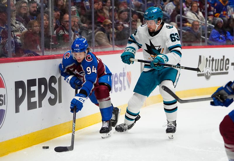 Nov 26, 2025; Denver, Colorado, USA; Colorado Avalanche left wing Joel Kiviranta (94) and San Jose Sharks center Zack Ostapchuk (63) during the first period at Ball Arena. Mandatory Credit: Ron Chenoy-Imagn Images