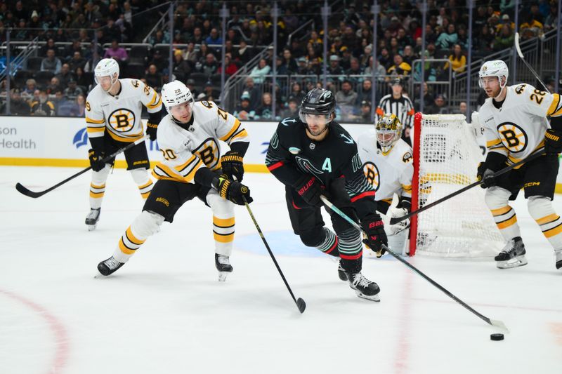 Jan 6, 2026; Seattle, Washington, USA; Seattle Kraken center Matty Beniers (10) plays the puck while defended by Boston Bruins defenseman Henri Jokiharju (20) during the second period at Climate Pledge Arena. Mandatory Credit: Steven Bisig-Imagn Images
