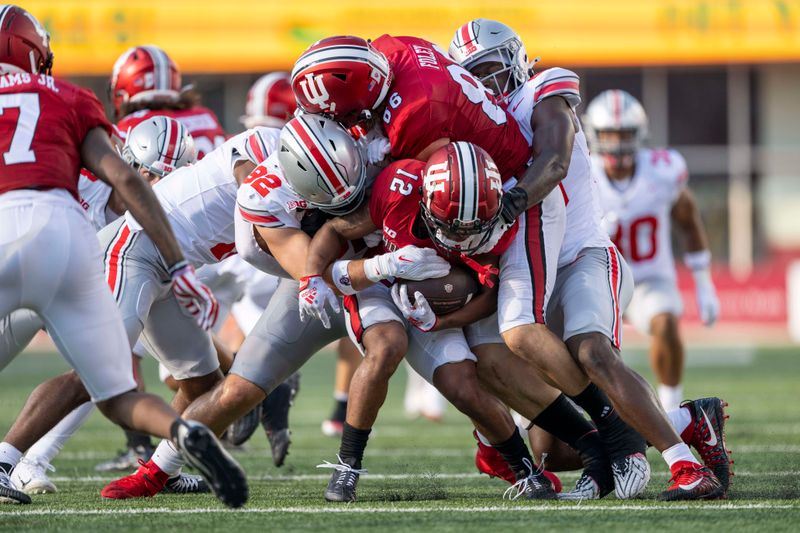 Sep 2, 2023; Bloomington, Indiana, USA; Indiana Hoosiers running back Jaylin Lucas (12) is tackled during the second half against the Ohio State Buckeyes at Memorial Stadium. Mandatory Credit: Marc Lebryk-USA TODAY Sports