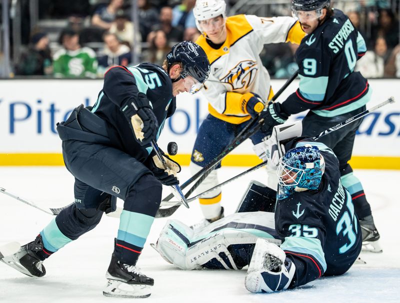 Mar 10, 2026; Seattle, Washington, USA; Seattle Kraken defenseman Ryan Lindgren (55), left, and goalie Joey Daccord (35) attempt to clear the puck during the third period against the Nashville Predators at Climate Pledge Arena. Mandatory Credit: Stephen Brashear-Imagn Images