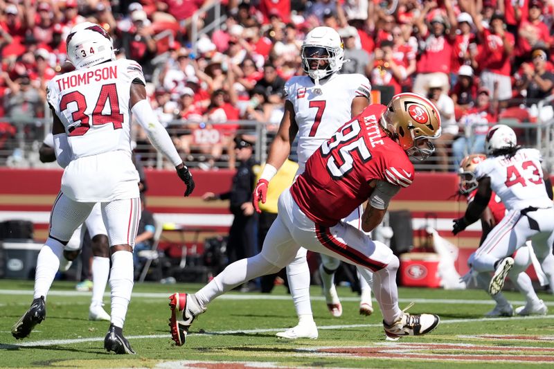 San Francisco 49ers tight end George Kittle (85) scores between Arizona Cardinals safety Jalen Thompson (34) and linebacker Kyzir White (7) during the first half of an NFL football game in Santa Clara, Calif., Sunday, Oct. 6, 2024. (AP Photo/Godofredo A. Vásquez)