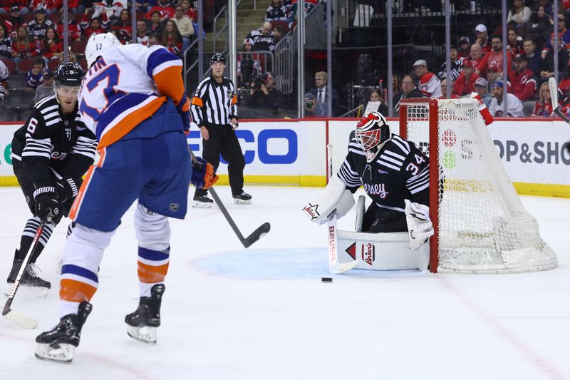 Apr 15, 2024; Newark, New Jersey, USA; New Jersey Devils goaltender Jake Allen (34) makes a save on New York Islanders left wing Matt Martin (17) during the first period at Prudential Center. Mandatory Credit: Ed Mulholland-USA TODAY Sports