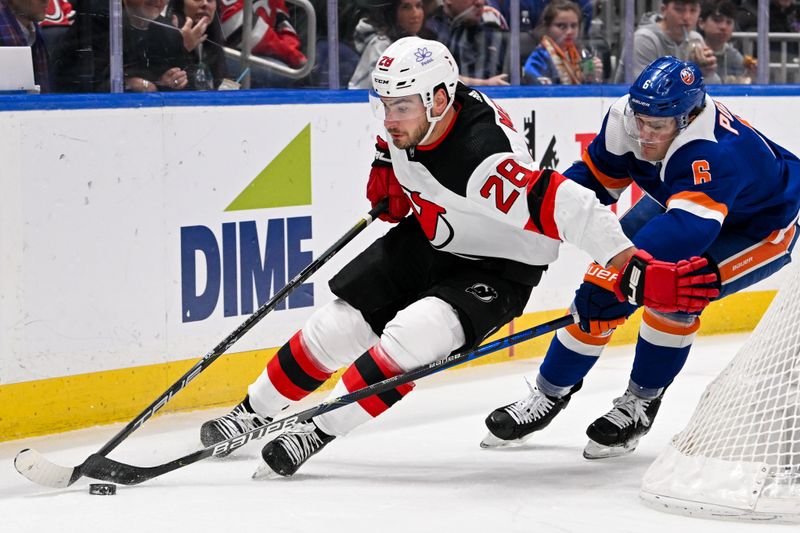 Mar 24, 2024; Elmont, New York, USA;  New Jersey Devils right wing Timo Meier (28) skates the puck from behind the net chased by New York Islanders defenseman Ryan Pulock (6) during the first period at UBS Arena. Mandatory Credit: Dennis Schneidler-USA TODAY Sports