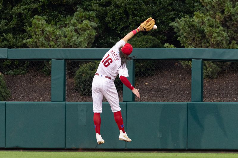 Aug 5, 2023; Philadelphia, Pennsylvania, USA; Philadelphia Phillies center fielder Brandon Marsh (16) is injured while attempting to catch the triple of Kansas City Royals second baseman Samad Taylor (not pictured) during the fifth inning at Citizens Bank Park. Mandatory Credit: Bill Streicher-USA TODAY Sports