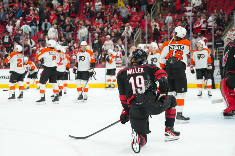 Oct 11, 2025; Raleigh, North Carolina, USA;  Carolina Hurricanes defenseman K'Andre Miller (19) looks up at the replay on the scoreboard before the goal by the Philadelphia Flyers was disallowed at Lenovo Center. Mandatory Credit: James Guillory-Imagn Images