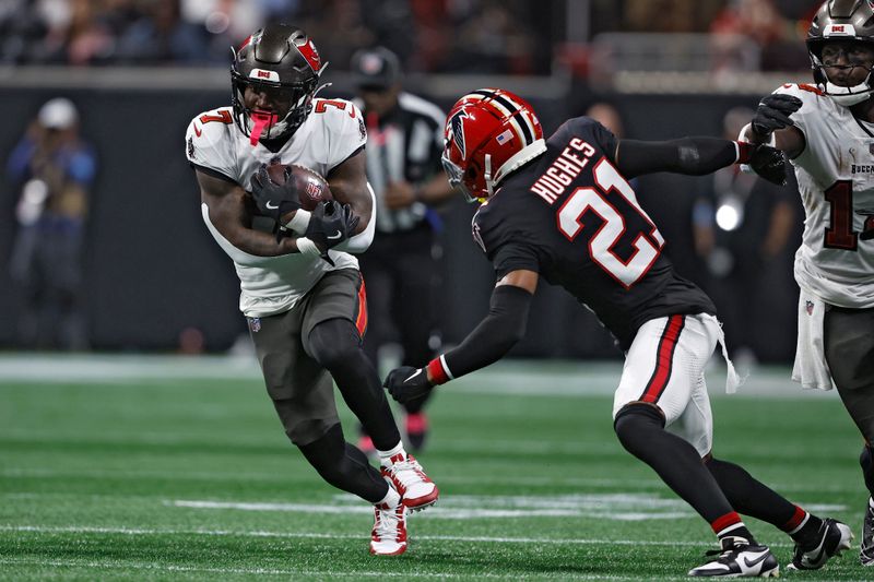 Tampa Bay Buccaneers running back Bucky Irving (7) runs against Atlanta Falcons cornerback Mike Hughes (21) during the first half of an NFL football game Thursday, Oct. 3, 2024, in Atlanta. (AP Photo/John Bazemore)