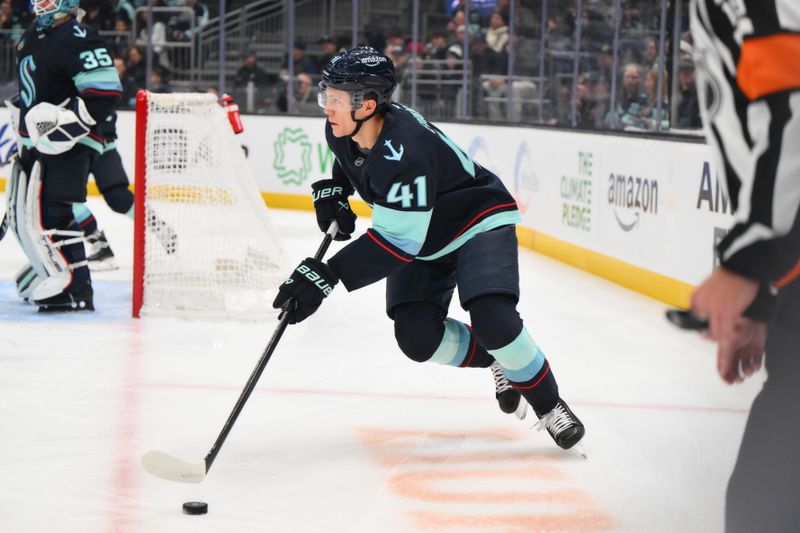 Nov 30, 2024; Seattle, Washington, USA; Seattle Kraken defenseman Ryker Evans (41) advances the puck against the San Jose Sharks during the first period at Climate Pledge Arena. Mandatory Credit: Steven Bisig-Imagn Images