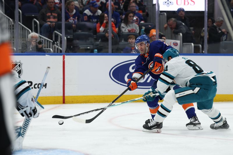 Jan 18, 2025; Elmont, New York, USA;  New York Islanders center Kyle Palmieri (21) takes a shot while San Jose Sharks defenseman Jan Rutta (84) defends during the second period at UBS Arena. Mandatory Credit: Thomas Salus-Imagn Images