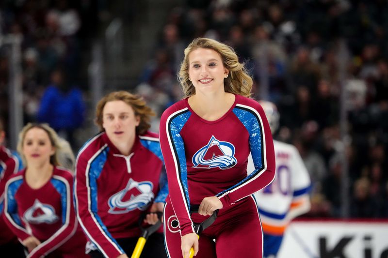 Jan 2, 2024; Denver, Colorado, USA; Colorado Avalanche ice patrol Sierra D'Aquila clears the rink in the first period against the New York Islanders at Ball Arena. Mandatory Credit: Ron Chenoy-USA TODAY Sports