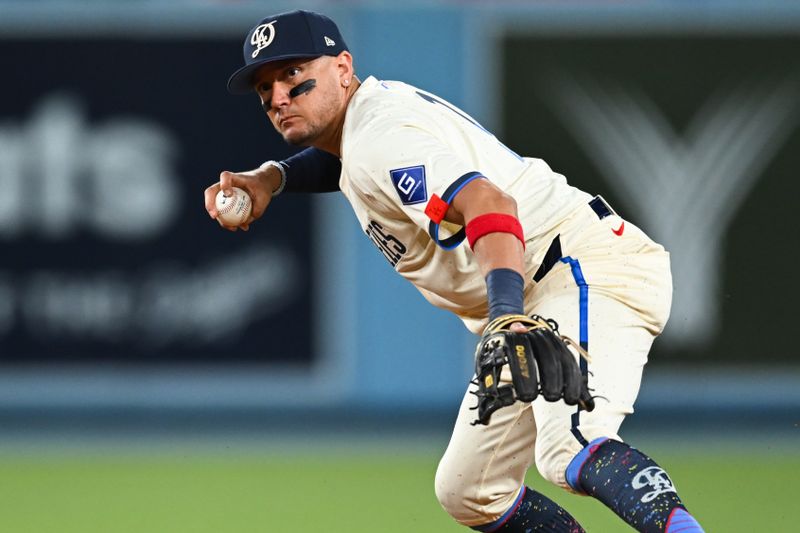 Jun 22, 2024; Los Angeles, California, USA; Los Angeles Dodgers shortstop Miguel Rojas (11) fields the ball against the Los Angeles Angels during the ninth inning at Dodger Stadium. Mandatory Credit: Jonathan Hui-USA TODAY Sports