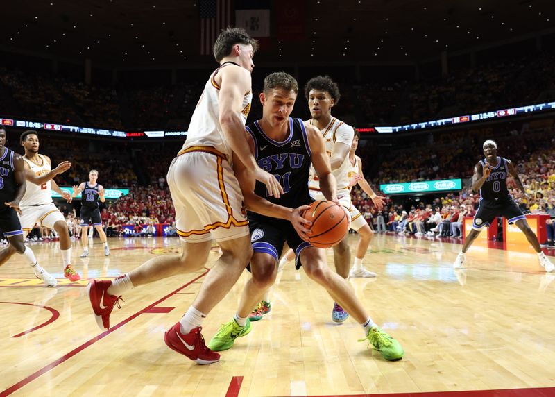 Mar 4, 2025; Ames, Iowa, USA; Brigham Young Cougars guard Trevin Knell (21) is defended by Iowa State Cyclones guard Nate Heise (0) and Iowa State Cyclones guard Curtis Jones (5) during the second half at James H. Hilton Coliseum. Mandatory Credit: Reese Strickland-Imagn Images