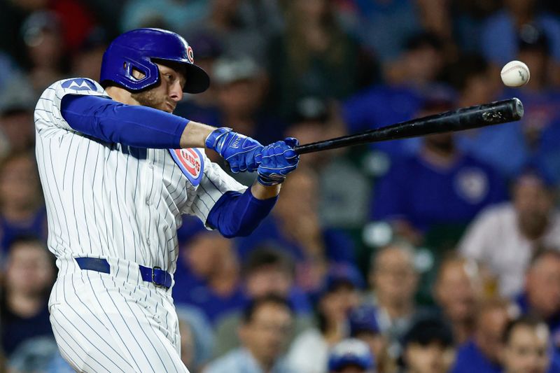 Sep 17, 2024; Chicago, Illinois, USA; Chicago Cubs first baseman Michael Busch (29) hits an RBI-single against the Oakland Athletics during the third inning at Wrigley Field. Mandatory Credit: Kamil Krzaczynski-Imagn Images