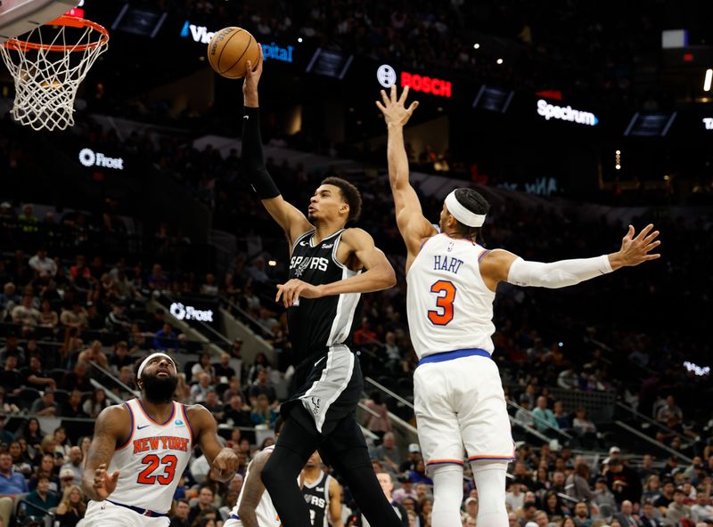 SAN ANTONIO, TX - MARCH 29:  Victor Wembanyama #1 of the San Antonio Spurs drives past Josh Hart #3 of the New York Knicks in the first half at Frost Bank Center on March 29, 2024 in San Antonio, Texas. NOTE TO USER: User expressly acknowledges and agrees that, by downloading and or using this photograph, User is consenting to terms and conditions of the Getty Images License Agreement. (Photo by Ronald Cortes/Getty Images)