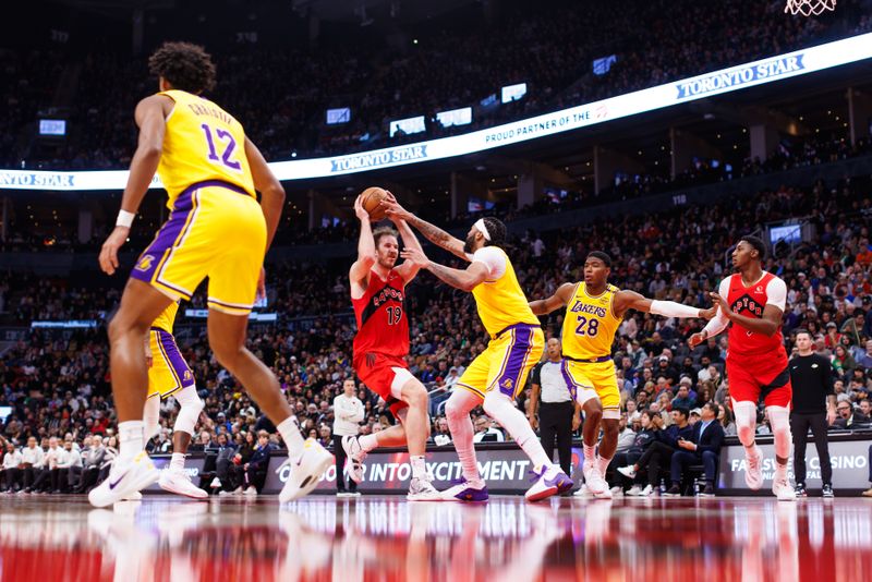 TORONTO, CANADA - NOVEMBER 1: Jakob Poeltl #19 of the Toronto Raptors drives against Anthony Davis #3 of the Los Angeles Lakers during the second half of their NBA game at Scotiabank Arena on November 1, 2024 in Toronto, Canada. NOTE TO USER: User expressly acknowledges and agrees that, by downloading and or using this photograph, User is consenting to the terms and conditions of the Getty Images License Agreement. (Photo by Cole Burston/Getty Images)