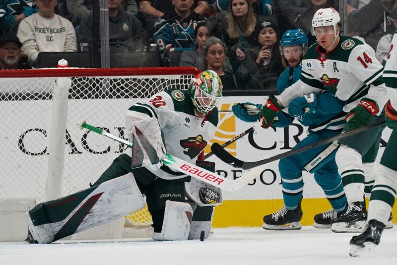 Apr 13, 2024; San Jose, California, USA; Minnesota Wild goaltender Jesper Wallstedt (30) makes a save against the San Jose Sharks as Minnesota Wild center Joel Eriksson Ek (14) looks on during the third period at SAP Center at San Jose. Mandatory Credit: David Gonzales-USA TODAY Sports