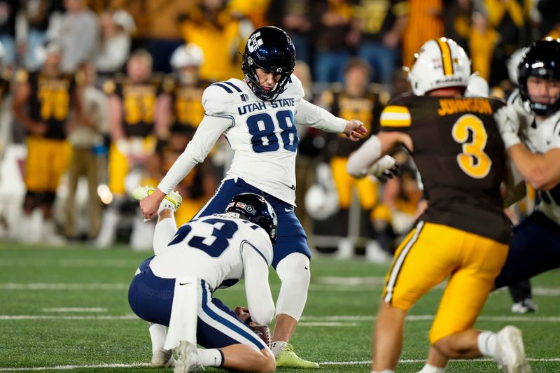 Oct 26, 2024; Laramie, Wyoming, USA; Utah State Aggies kicker Tanner Cragun (88) kicks a last second field goal against the Wyoming Cowboys during the fourth quarter at Jonah Field at War Memorial Stadium. Mandatory Credit: Troy Babbitt-Imagn Images