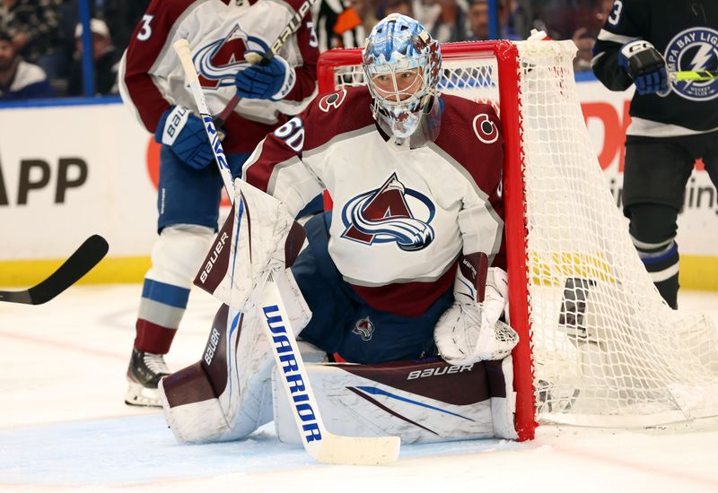 Feb 15, 2024; Tampa, Florida, USA; Colorado Avalanche goaltender Justus Annunen (60) defends the puck against the Tampa Bay Lightning during the third period at Amalie Arena. Mandatory Credit: Kim Klement Neitzel-USA TODAY Sports