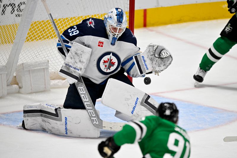 Apr 11, 2024; Dallas, Texas, USA; Winnipeg Jets goaltender Laurent Brossoit (39) stops a shot by Dallas Stars center Tyler Seguin (91) during the third period at the American Airlines Center. Mandatory Credit: Jerome Miron-USA TODAY Sports